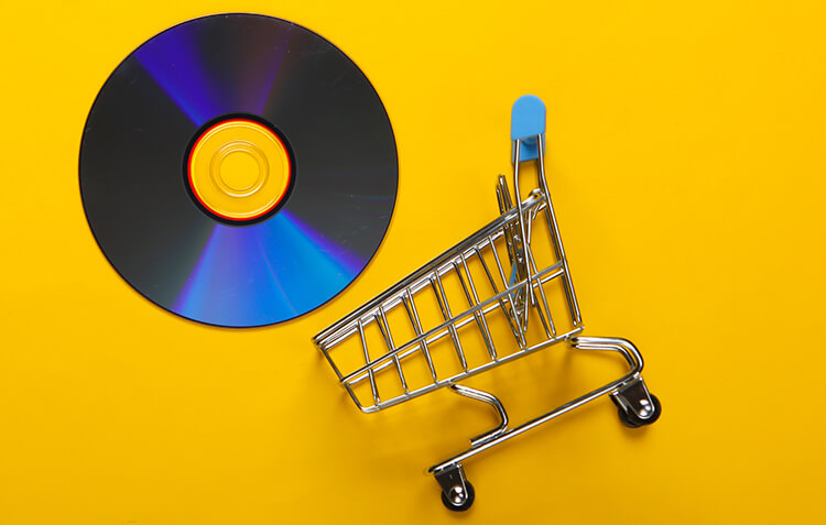 conceptual photograph of CD and relatively tiny shopping cart